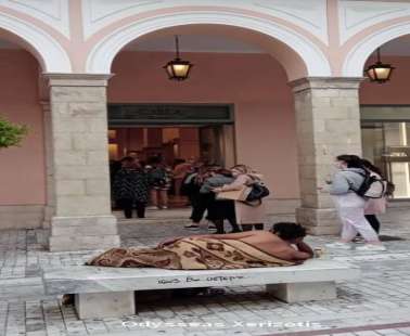 Ημίγυμνος άντρας, καλυμμένος με κουβέρτα, ξάπλωσε μπροστά από εμπορικό κεντρο